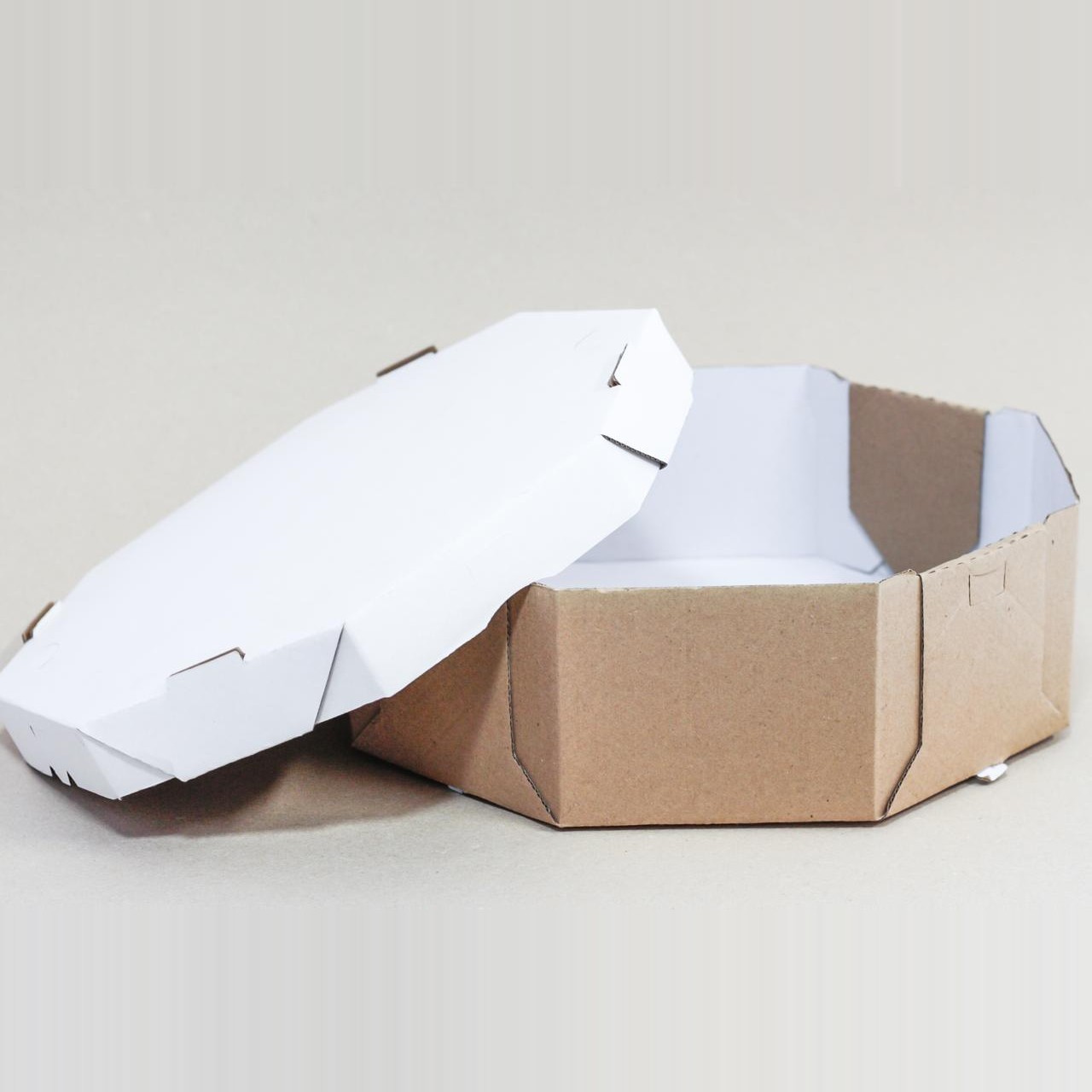 Caixa de Bolo e Torta Oitavada com base kraft e interior branco, tampa branca apoiada ao lado